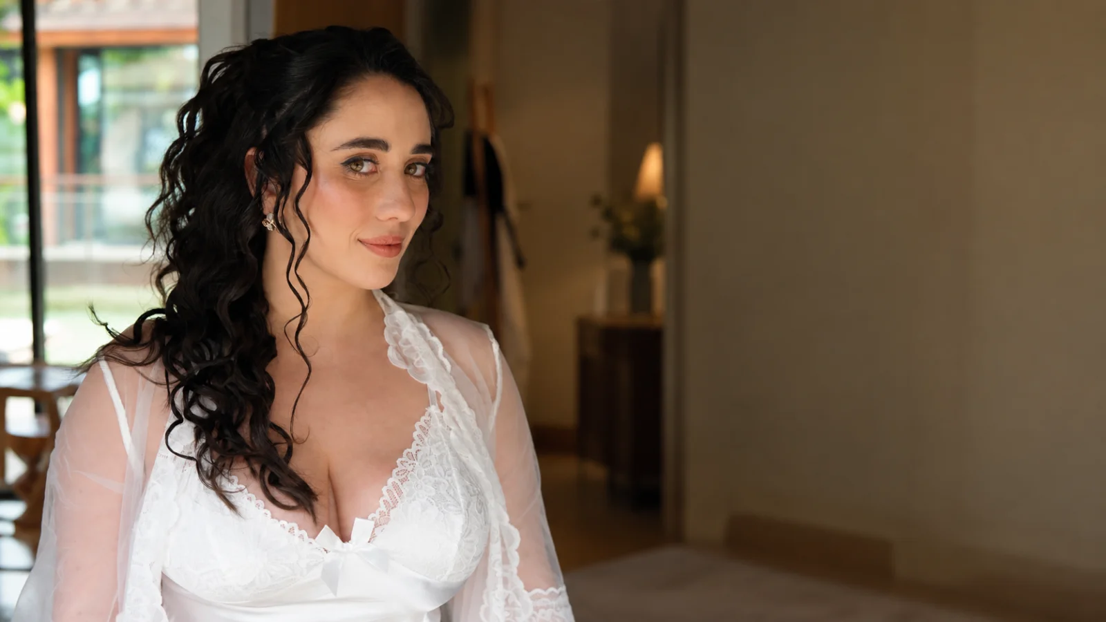 כלה עם שיער מתולתל שחור וארוך בתסרוקת חצי אסוף, עבודת מיכל לורן